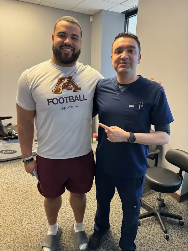 Dr. Manan Patel with a football athlete in the clinic